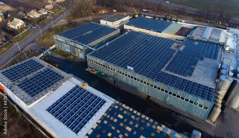 Old factory roofs covered with lots of solar cells. Production of green electricity concept. Aerial 