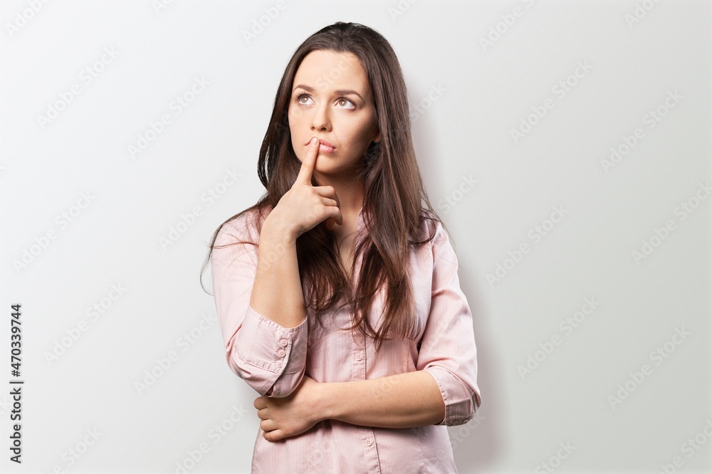 Thoughtful young woman looks aside has dreamy expression interesting