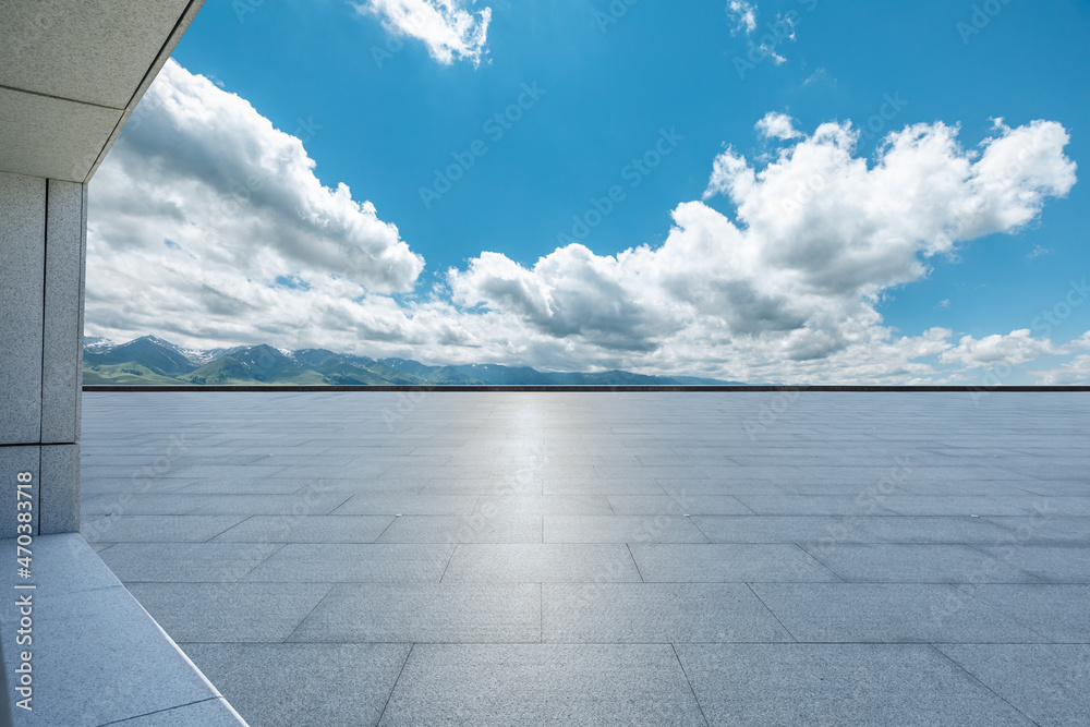 Empty square floor and mountains under blue sky