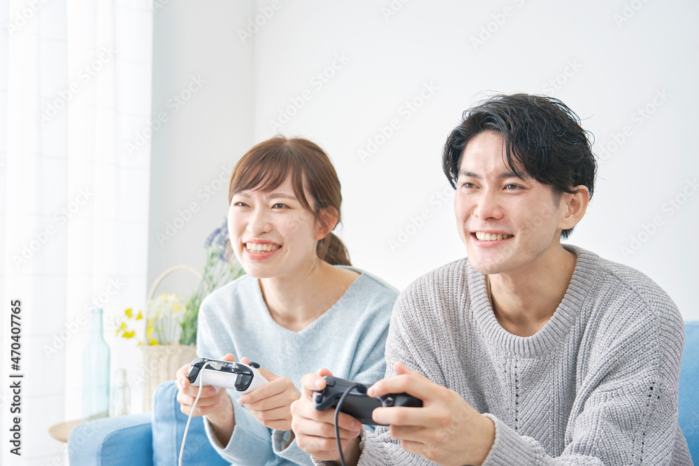 テレビゲームで遊ぶ男女