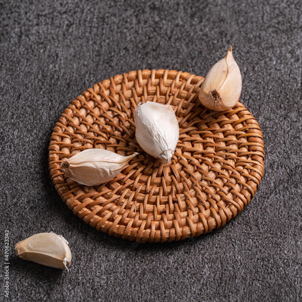 Fresh garlic cloves on black table background.