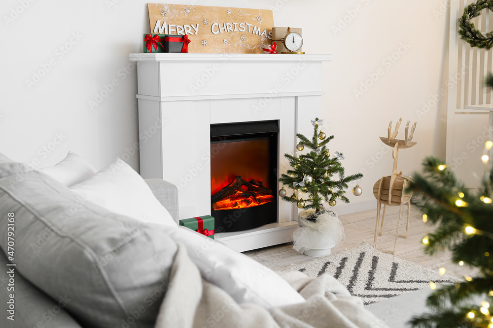 Small Christmas tree near fireplace in light living room