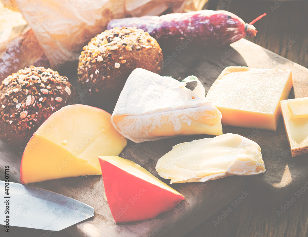 Closeup of various cheeses on wooden table with buns