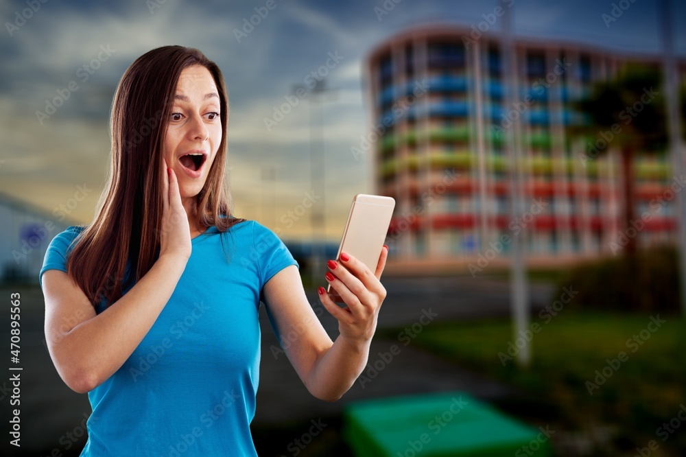 Beautiful Young Woman Using Smartphone Walking Through City Street