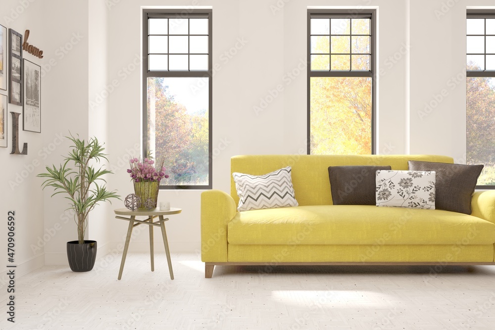 Stylish room in white color with sofa and autumn landscape in window. Scandinavian interior design. 