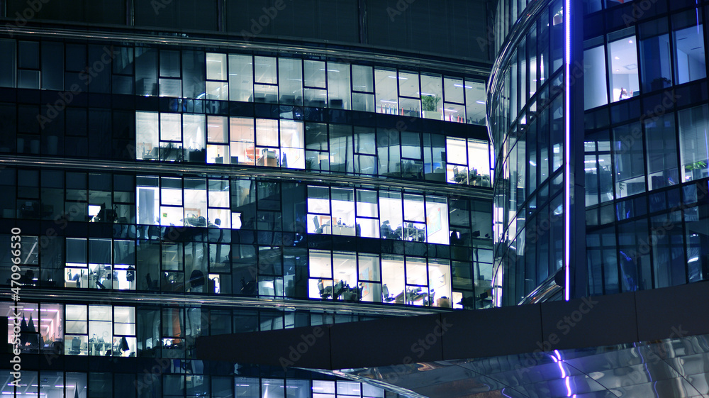 Corporate building at night - business concept. Glass wall office building .Modern office windows of