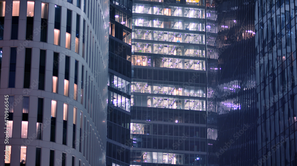 Corporate building at night - business concept. Glass wall office building .Modern office windows of