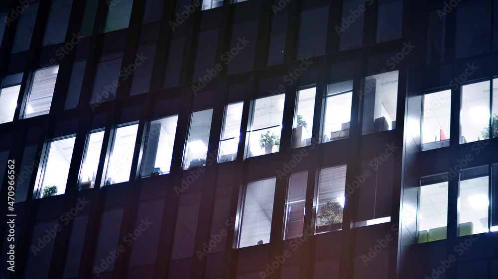 Corporate building at night - business concept. Glass wall office building .Modern office windows of