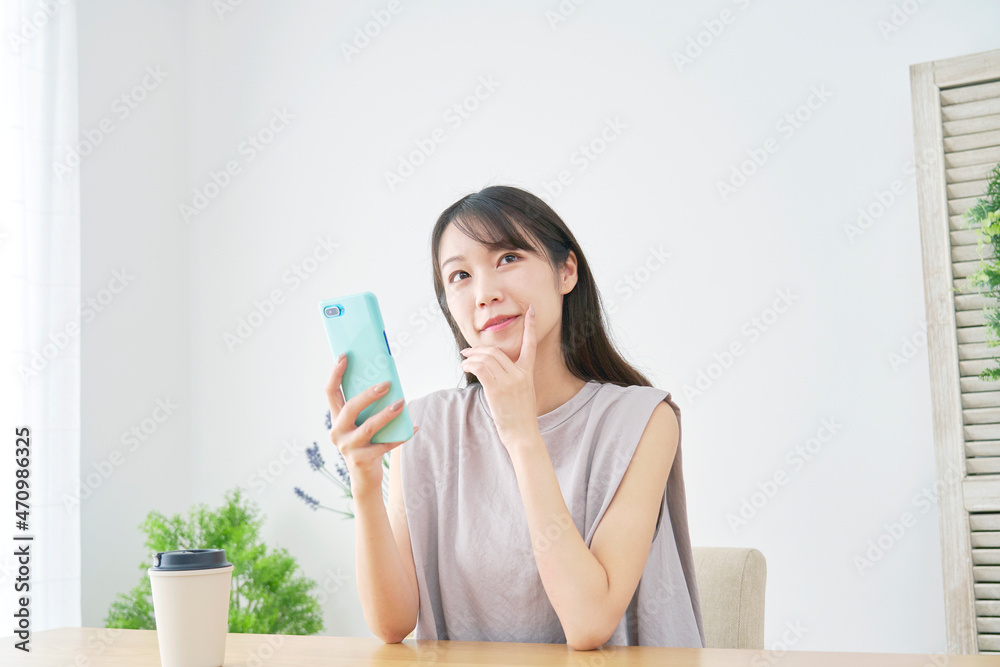 女性　考える　スマホ　リビング