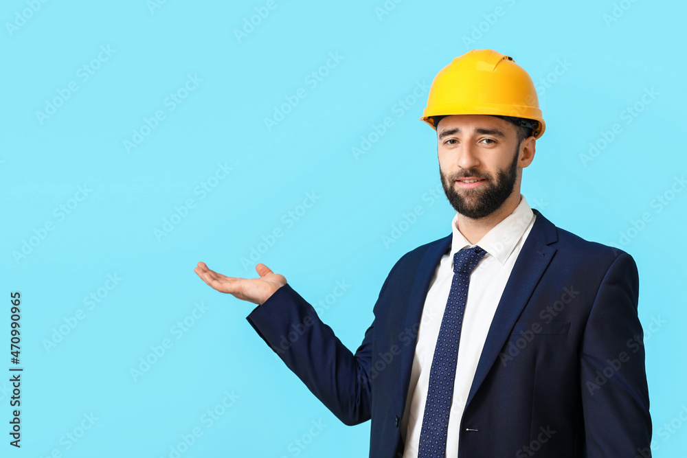 Industrial engineer in hardhat showing something on blue background