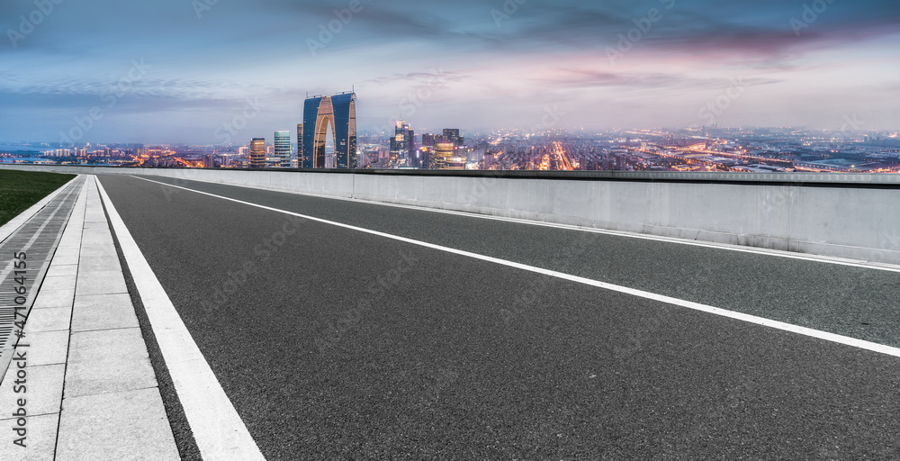 空旷的柏油路、城市天际线和建筑景观，中国。