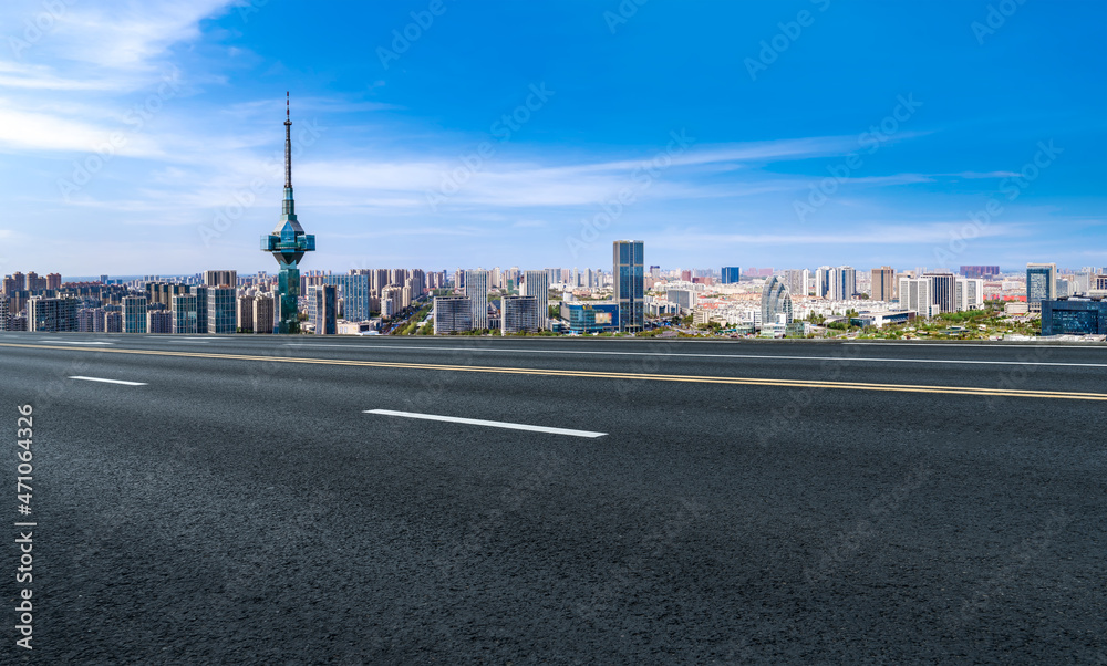 空旷的柏油路、城市天际线和建筑景观，中国。