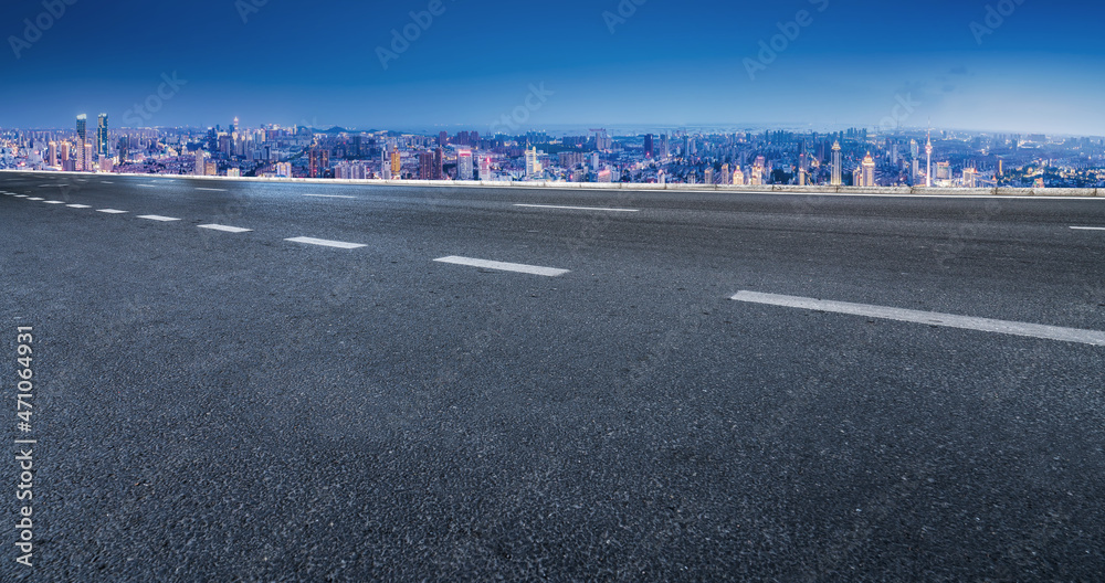 空旷的柏油路、城市天际线和建筑景观，中国。