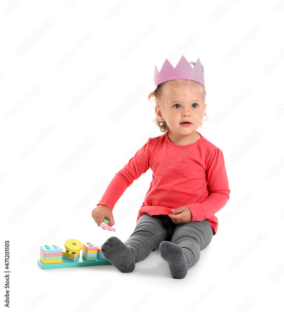 Cute baby girl playing with toys on white background