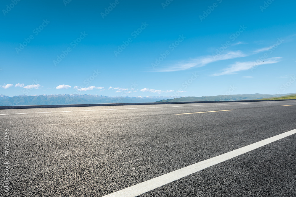 Asphalt road and mountain under blue sky. Highway and mountain background.