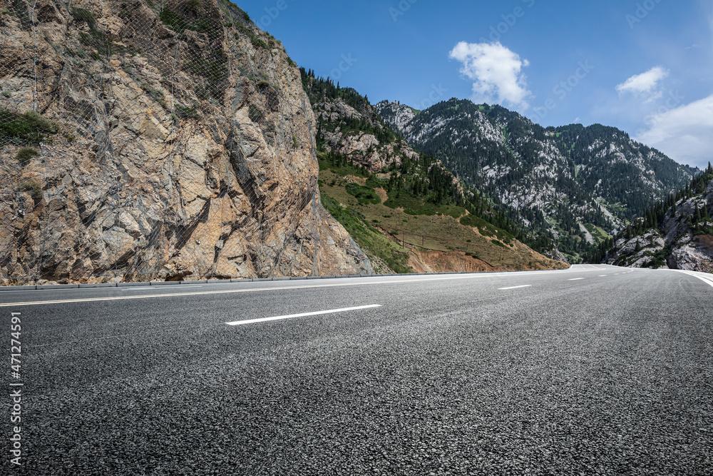 蓝天下的沥青路和山。公路和山的背景。