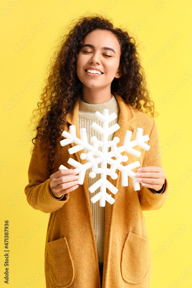 美丽的非裔美国妇女，黄色背景下有大片雪花