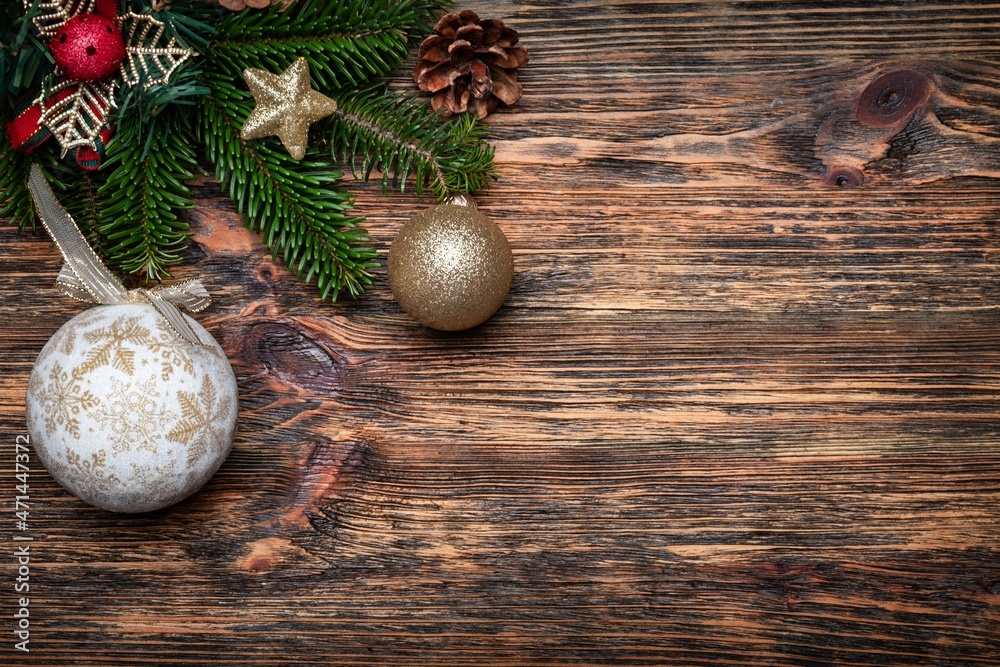 Christmas or New Year decoration object on wooden background, fur-tree branches, colorful glass ball