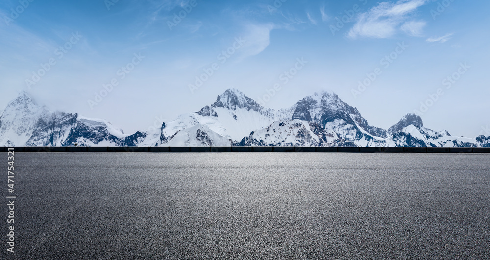 蓝天下的沥青路和雪山。公路和山脉背景。