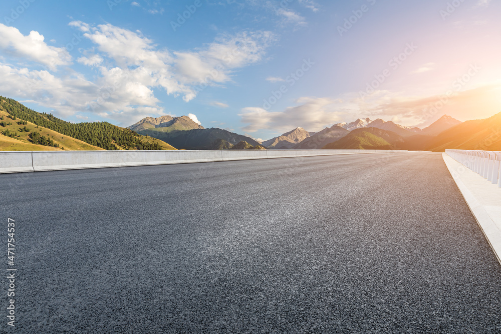 日出时的柏油路和山景。公路和山脉背景。