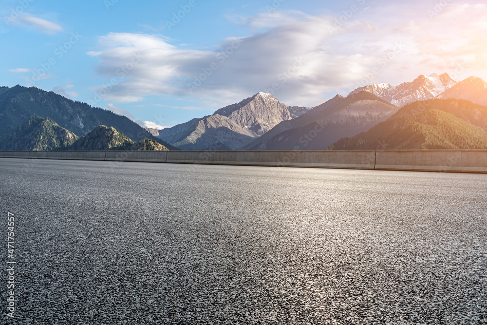 日出时的柏油路和山景。公路和山脉背景。