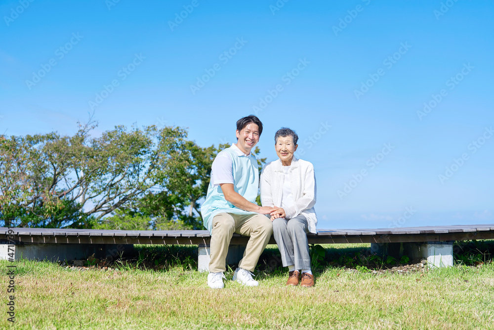 介護士と高齢者　屋外