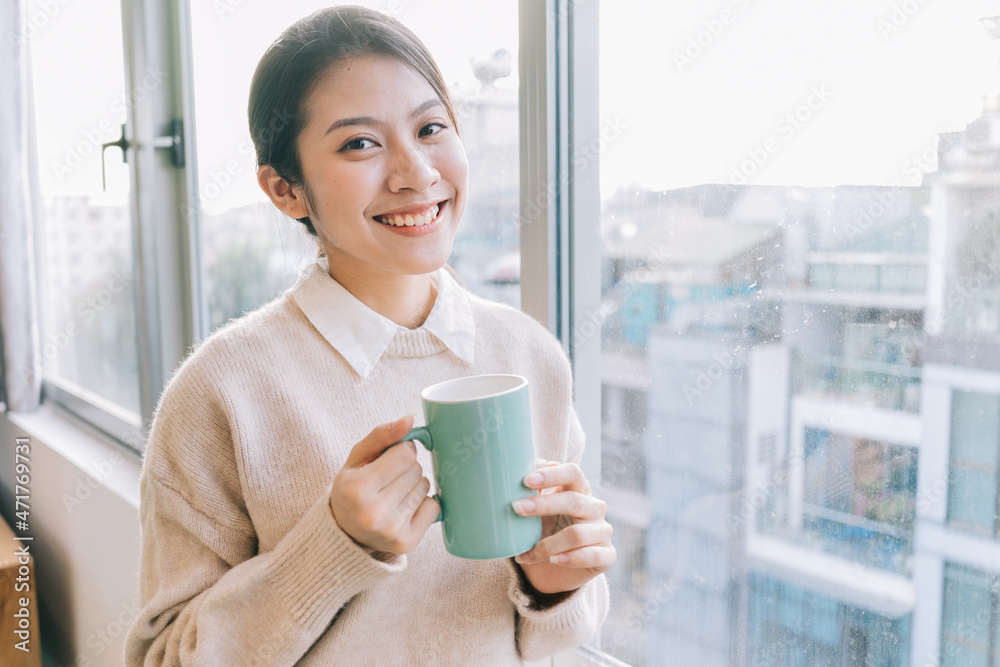 年轻的亚洲女商人早上喝茶