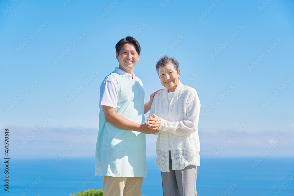 介護士と高齢者　屋外