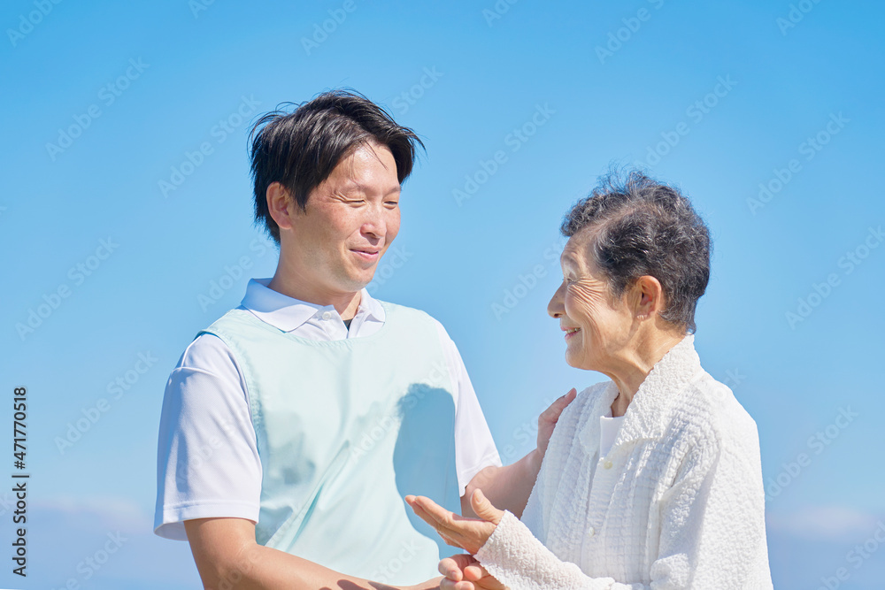 介護士と高齢者　屋外