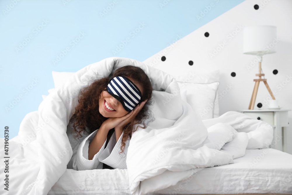 Morning of young woman with sleeping mask lying in bed