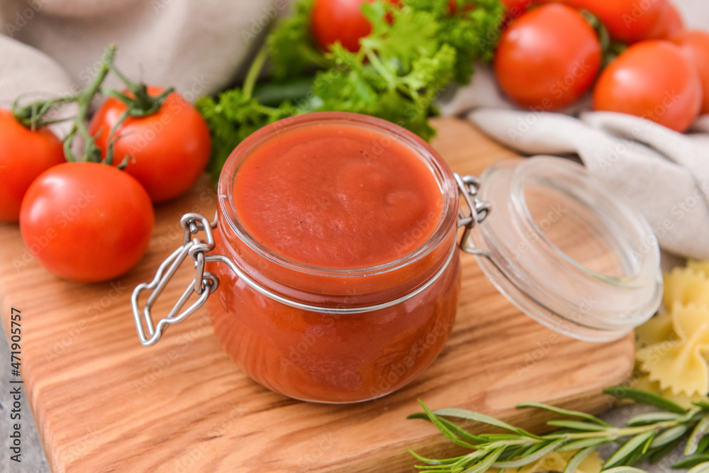 Jar with organic tomato sauce on table