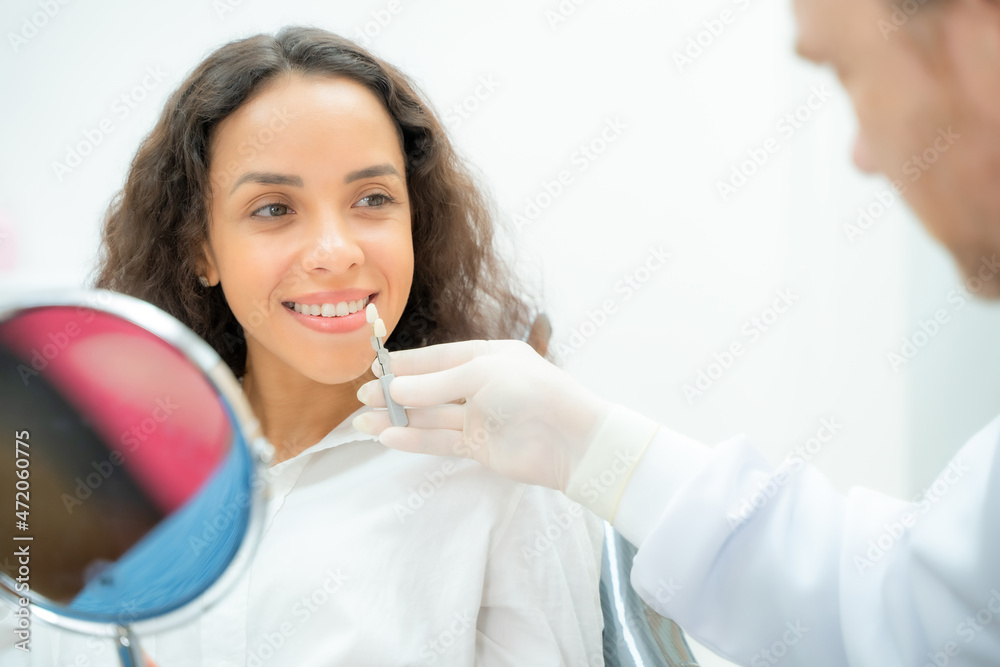 Dentist checking and selecting color of young women,Compare teeth with sampler in dentistry.