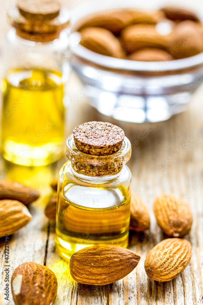 natural oil and almond in cosmetic set on table background