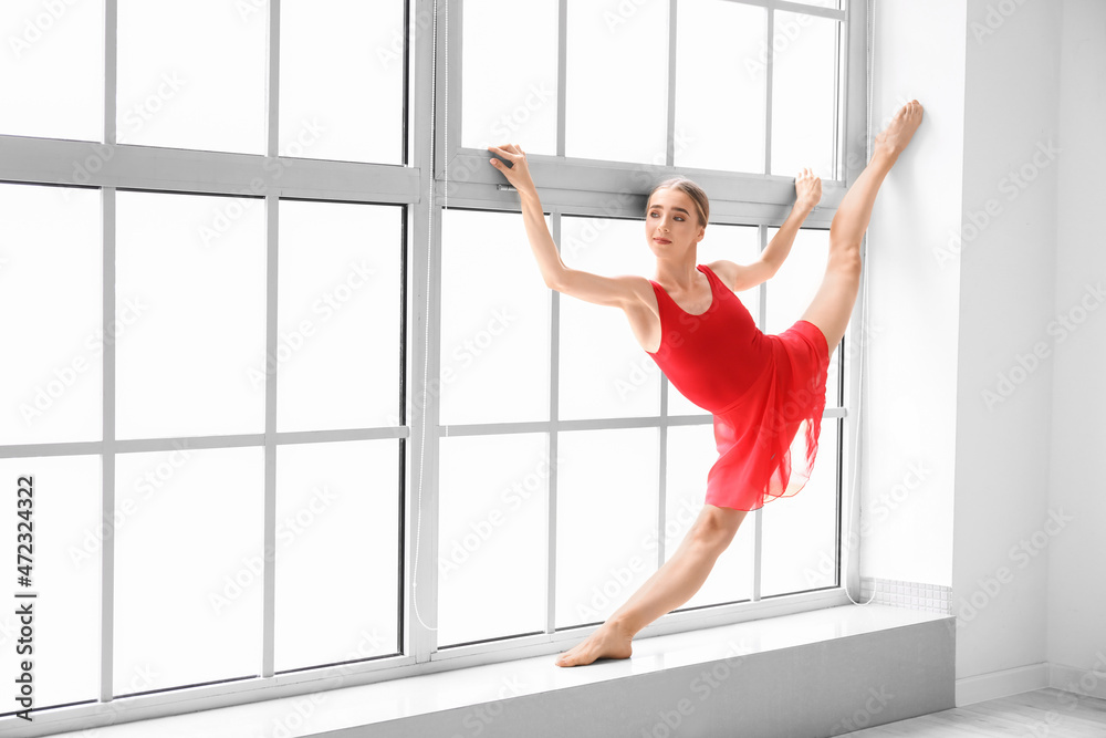 Beautiful young woman doing gymnastics in gym