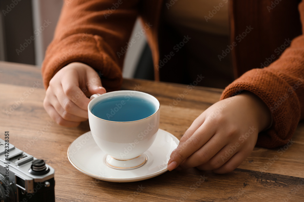 餐桌上喝蝴蝶豌豆花茶的女人