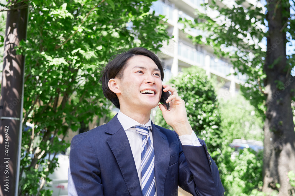 ビジネスマン　電話する　屋外