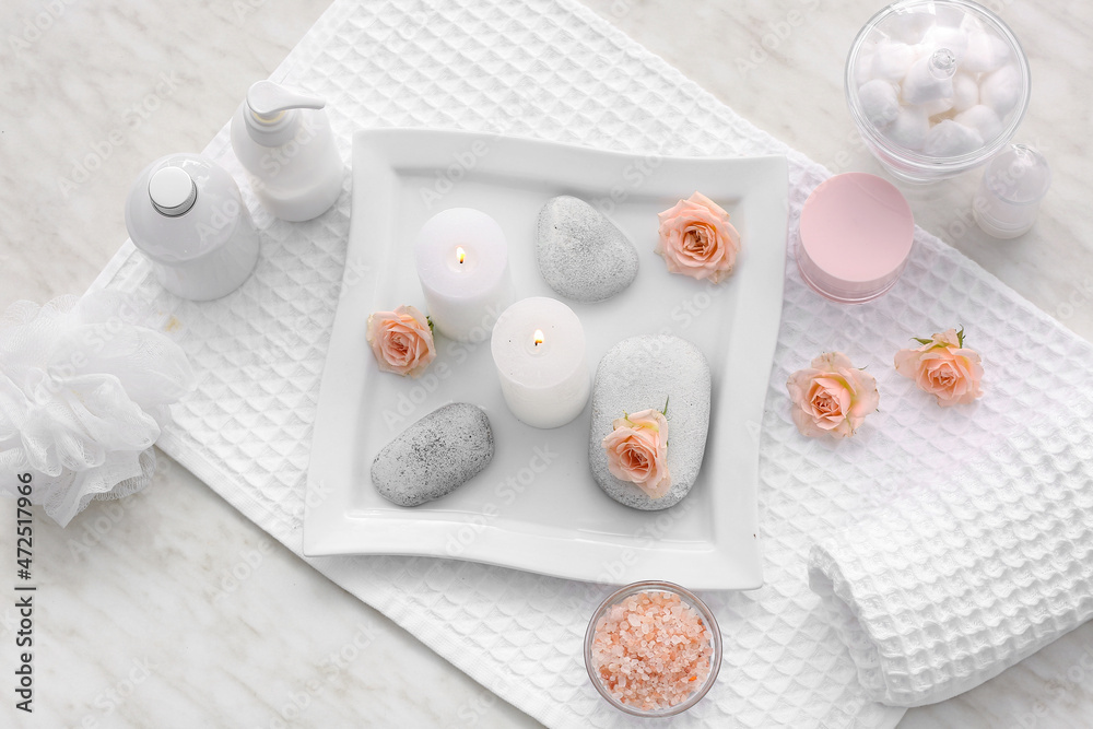 Spa set with burning candle on light background