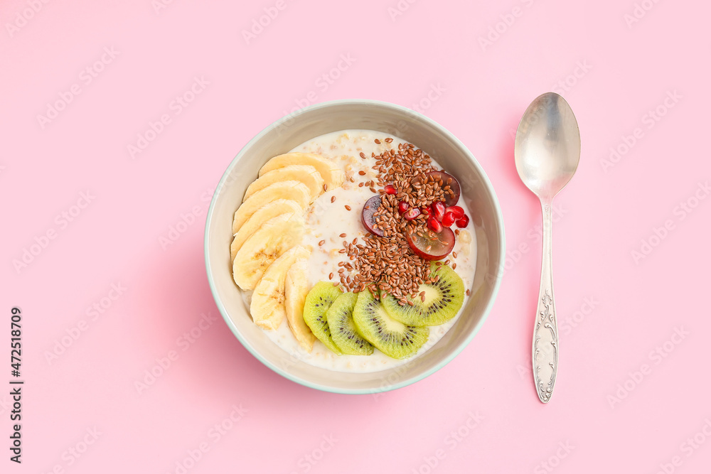 Tasty yoghurt with fruits and flax seeds in bowl on color background