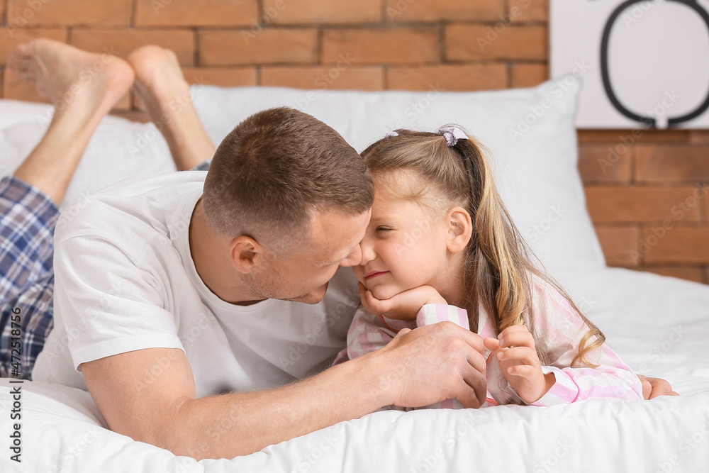 Father with little daughter on bed at home. Family bedtime