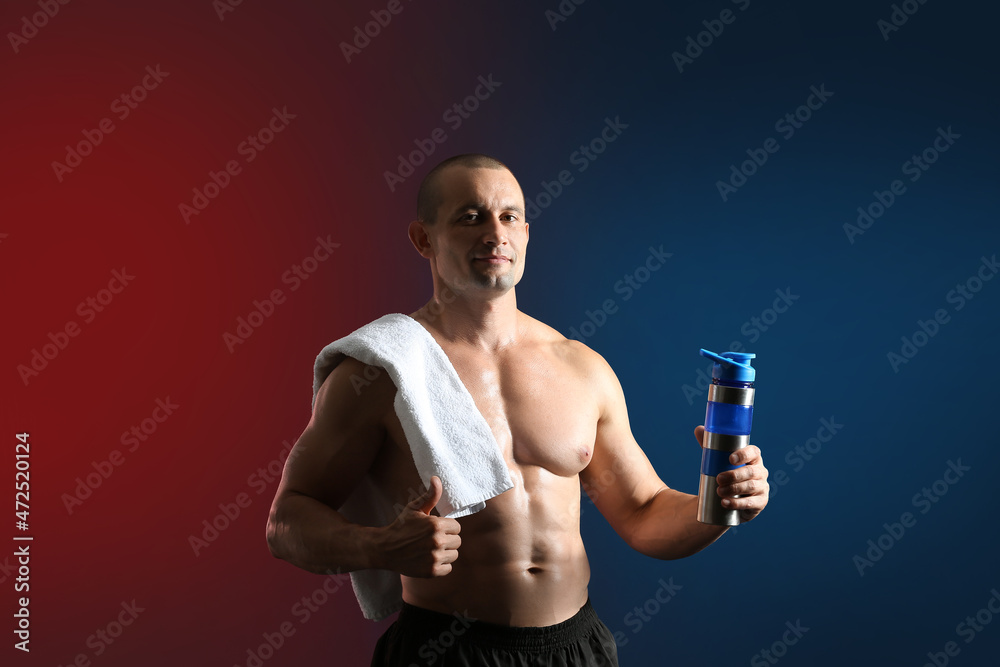 Male bodybuilder with protein shake on dark background