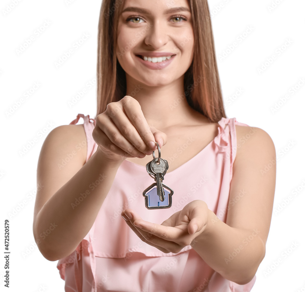 Smiling young woman with key from house on white background