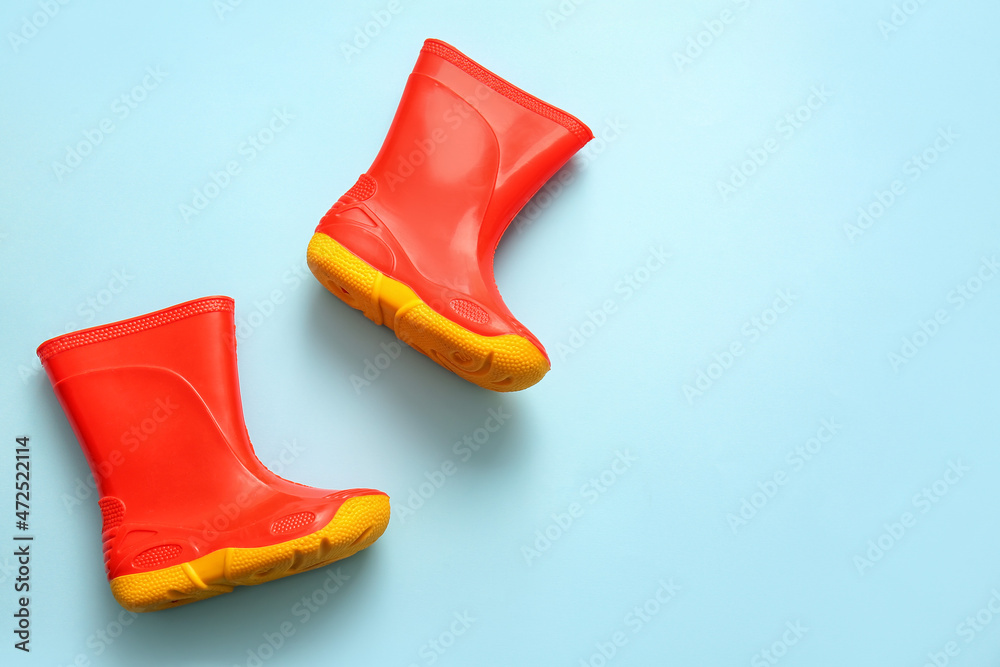 Pair of rubber boots on blue background