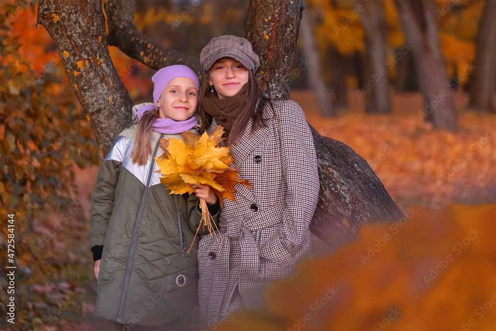 Happy sisters hugs outdoors.  Autumn time together.