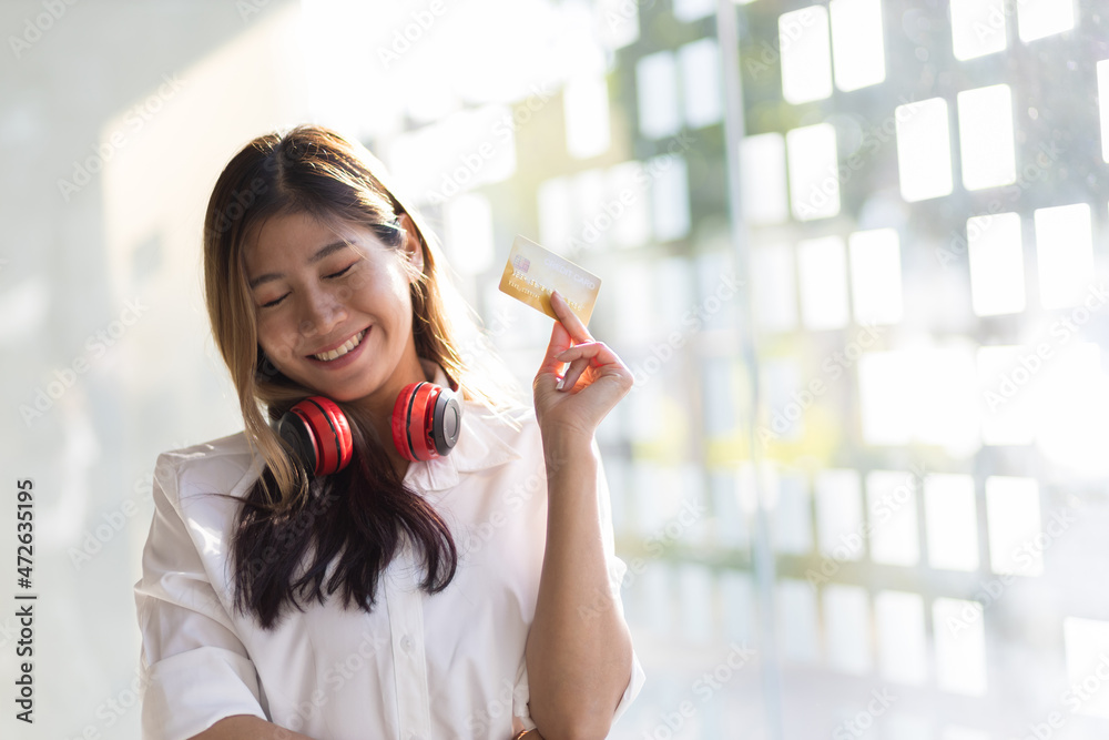 快乐微笑的女孩，手里拿着一张信用卡。