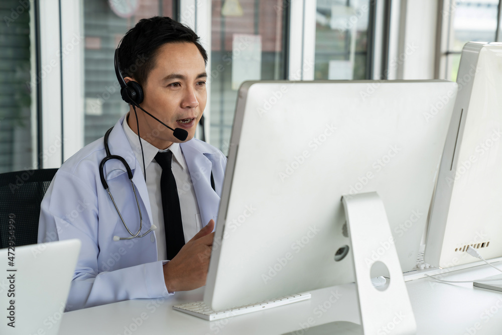 Doctor wearing headset talking actively on video call in a clinic or hospital . Concept of telehealt