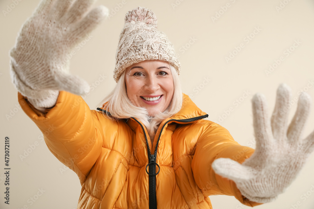 美丽的成熟女人穿着彩色背景的冬装