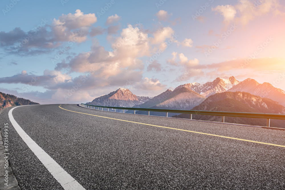 日出时的柏油路和山景。公路和山脉背景。