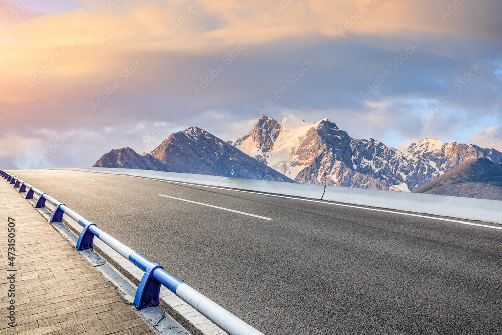 日出时的柏油路和山景。公路和山脉背景。