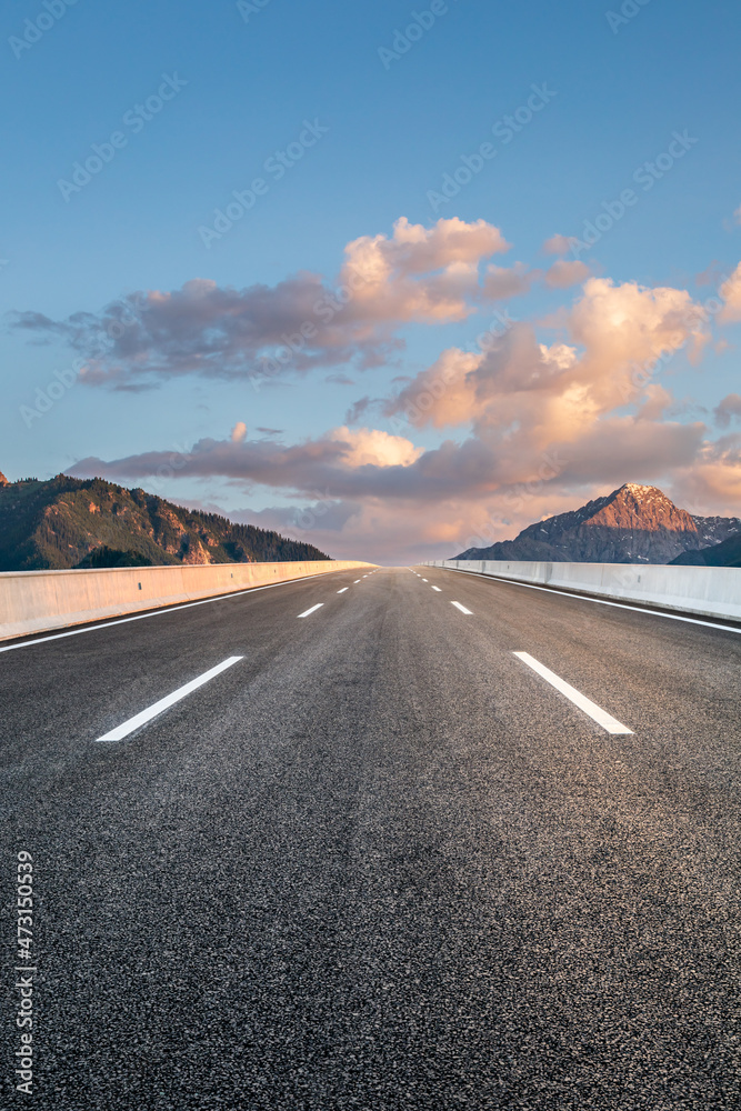 日出时的柏油路和山景。公路和山脉背景。