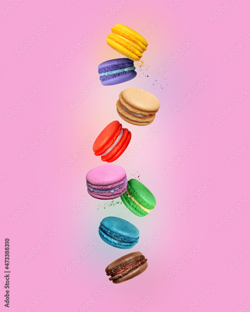 Сolored macaroons with different flavors in the air on pink background